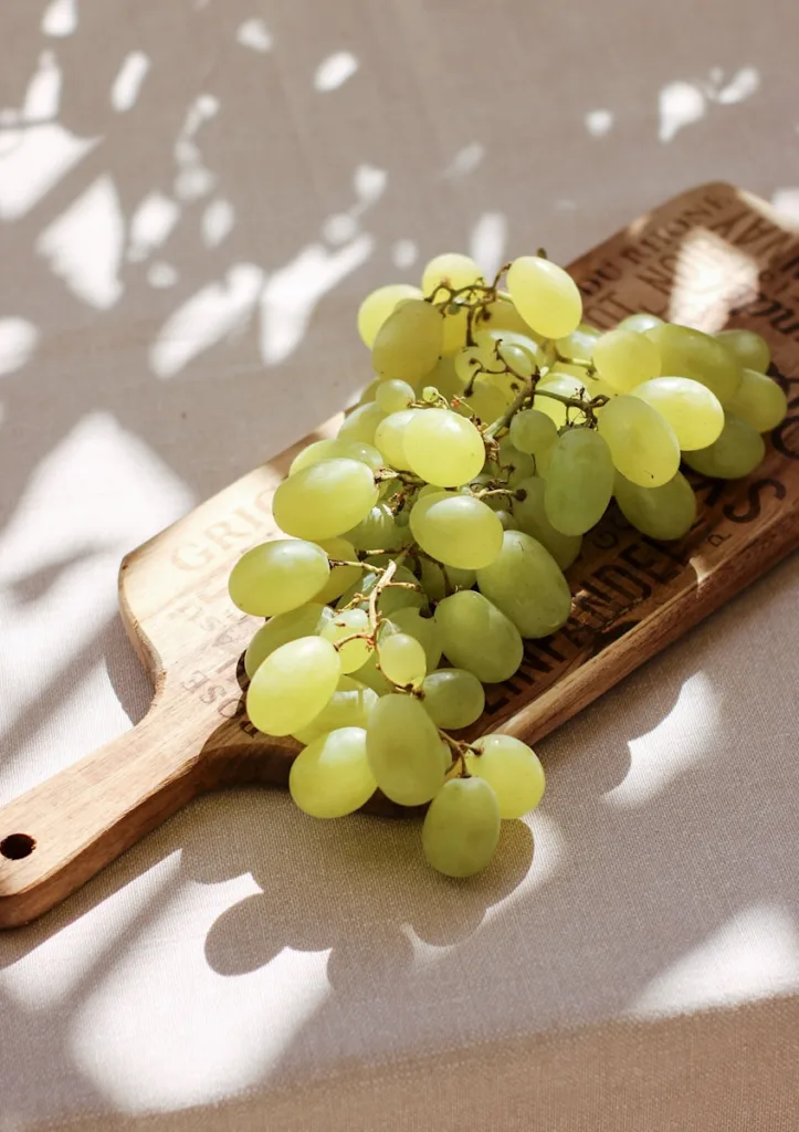 green grapes on brown wooden chopping board