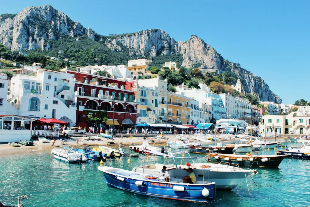 white and blue boat on body of water near buildings during daytime